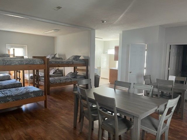 A room with bunk beds and a table and chairs