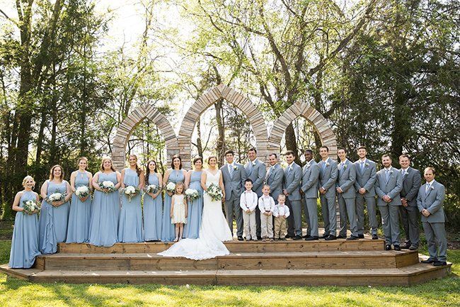 The bride and groom are posing for a picture with their wedding party.