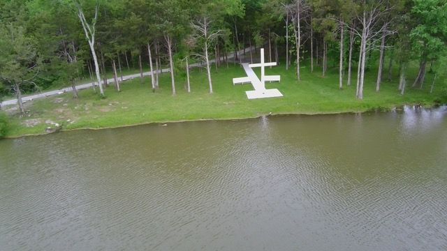 An aerial view of a small island in the middle of a lake surrounded by trees