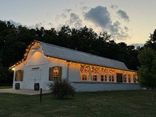 A white barn with lights on the roof