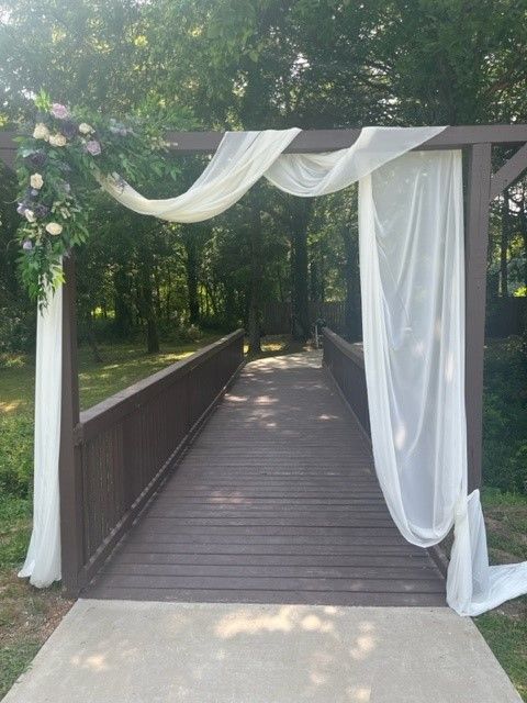 a wooden bridge with a white curtain hanging over it .