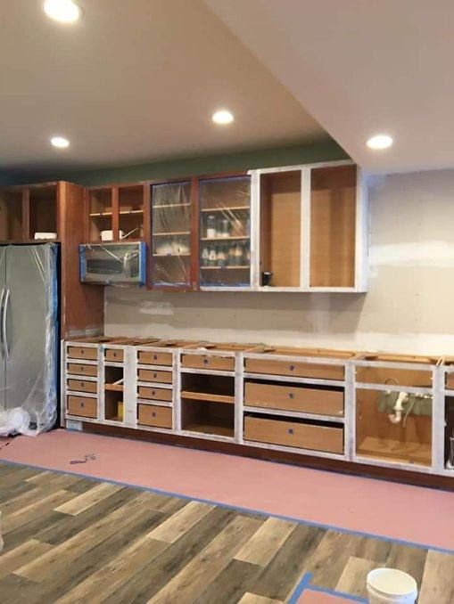 A kitchen under construction with wooden cabinets and drawers