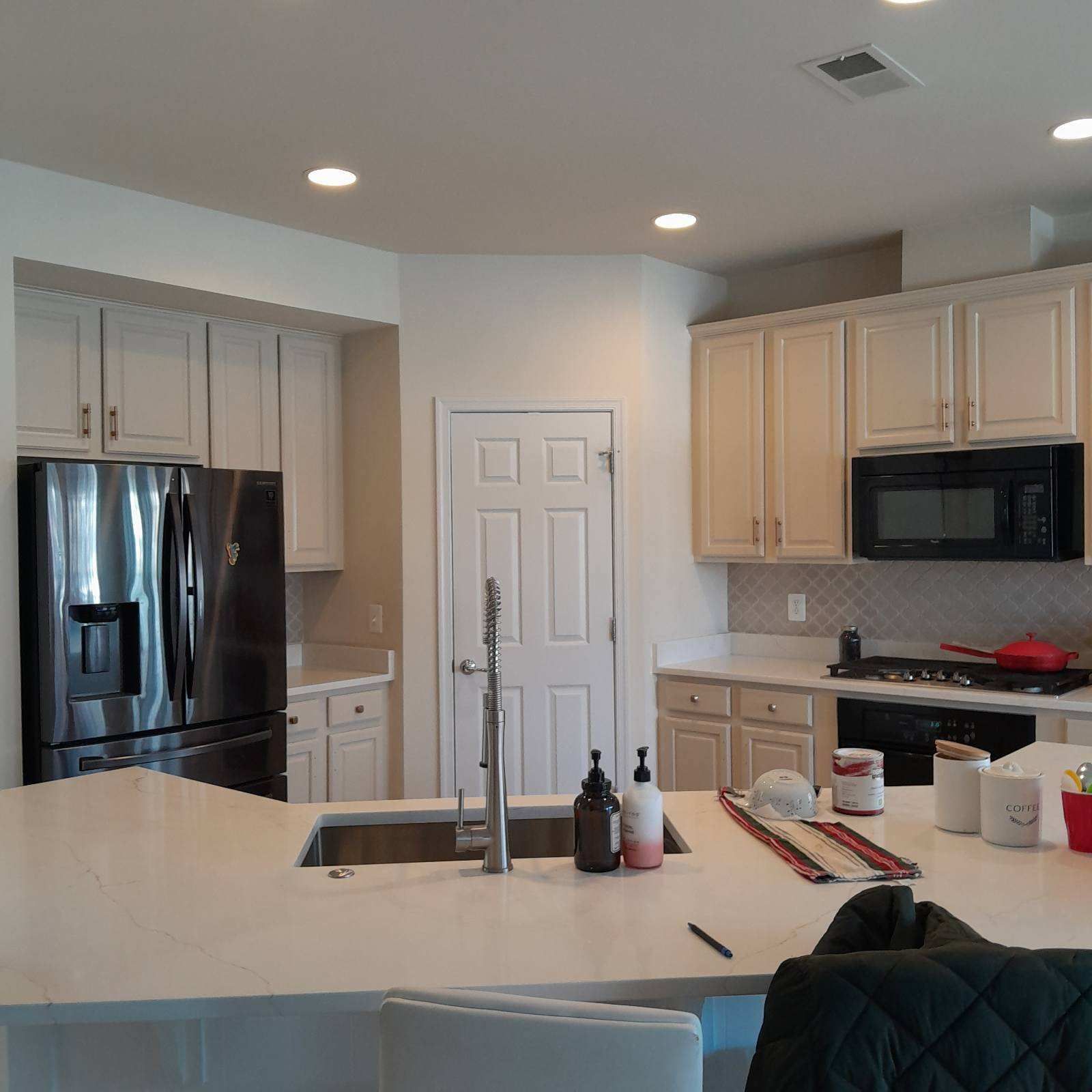 A kitchen with stainless steel appliances and white cabinets