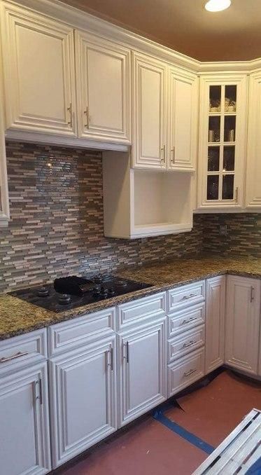 A kitchen with white cabinets and granite counter tops