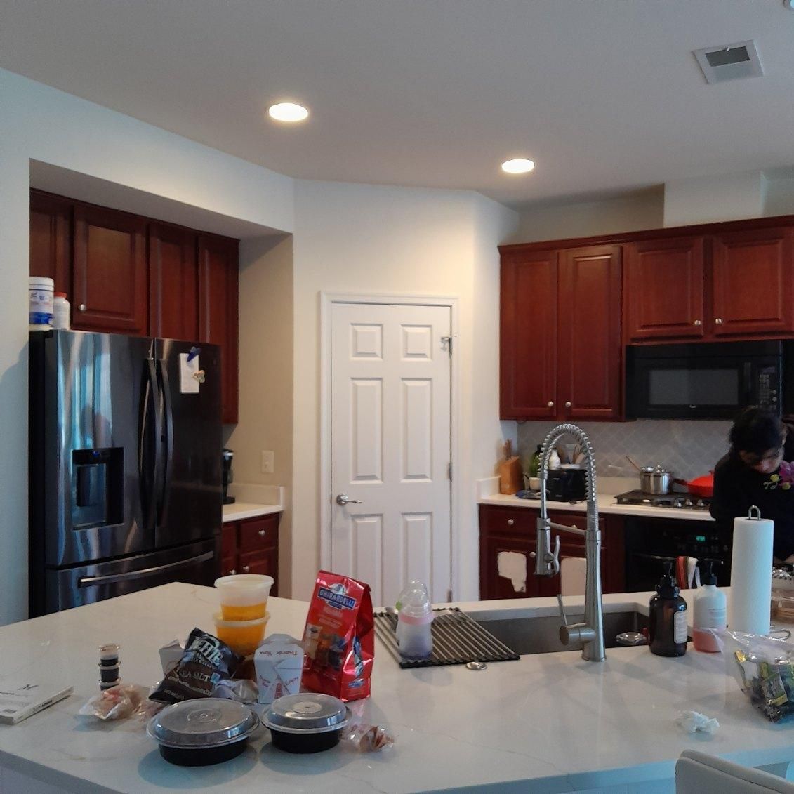 A kitchen with red cabinets and a stainless steel refrigerator