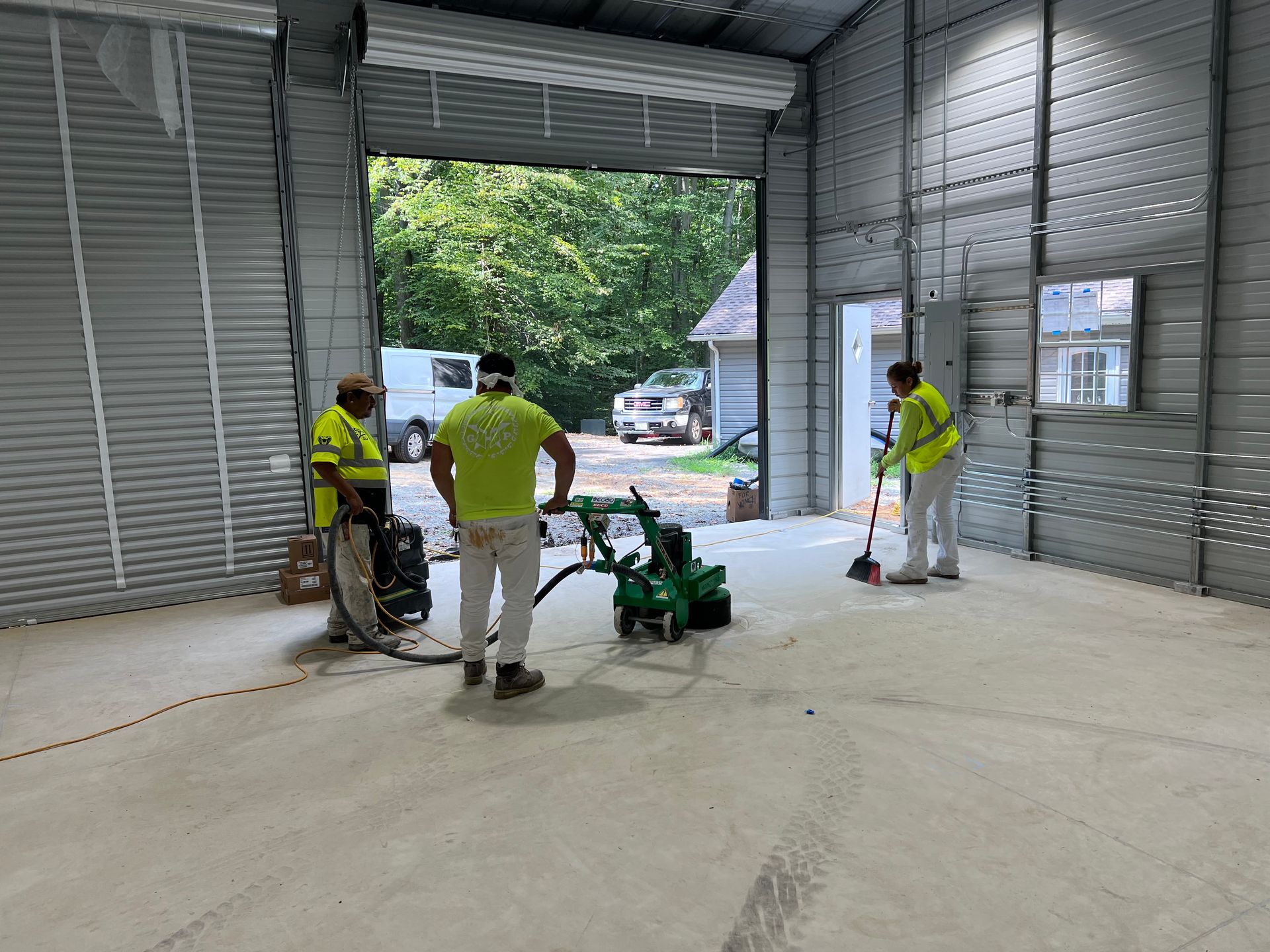 A group of people are cleaning a garage floor.
