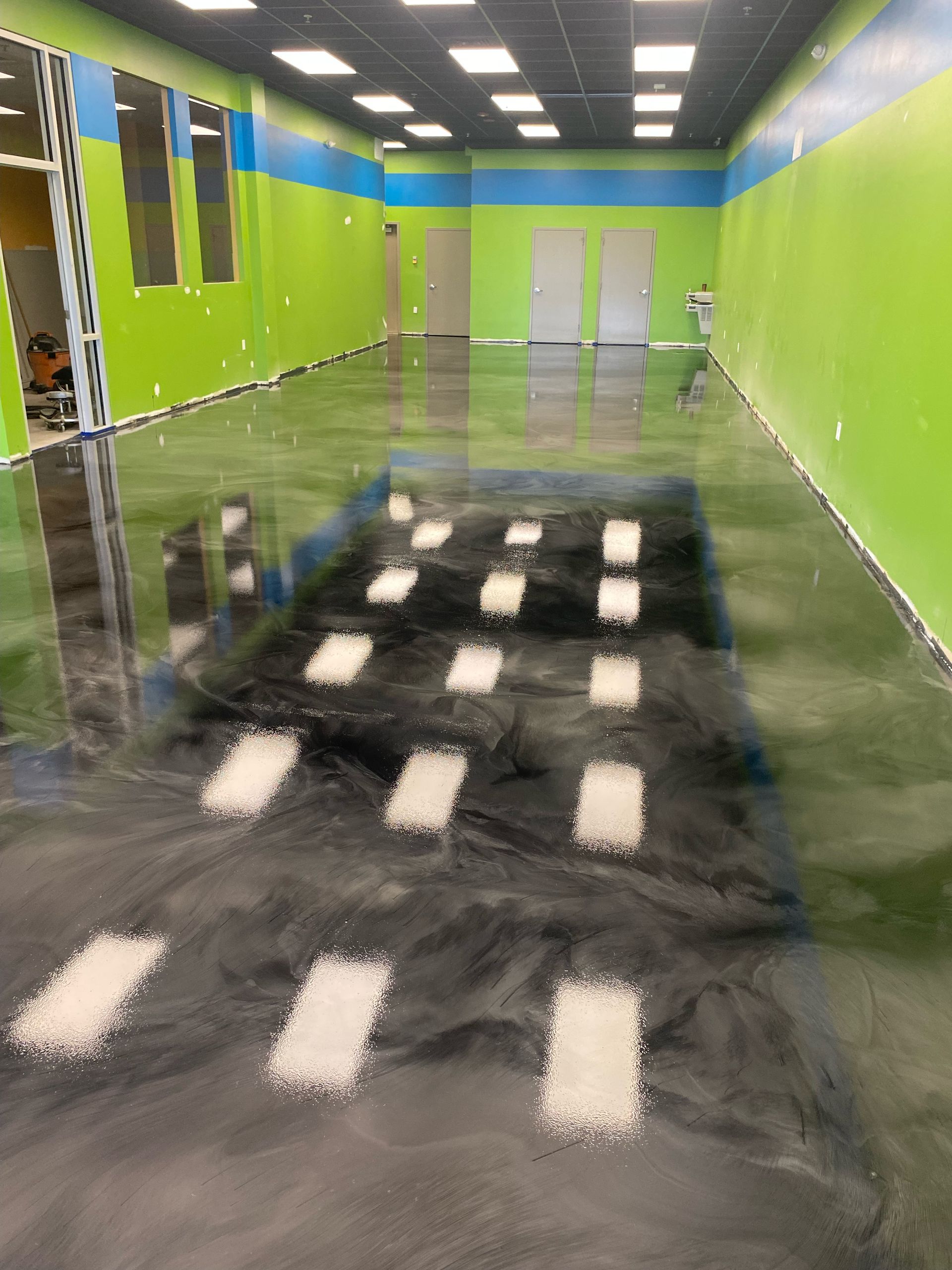 A large room with a shiny floor and green walls.