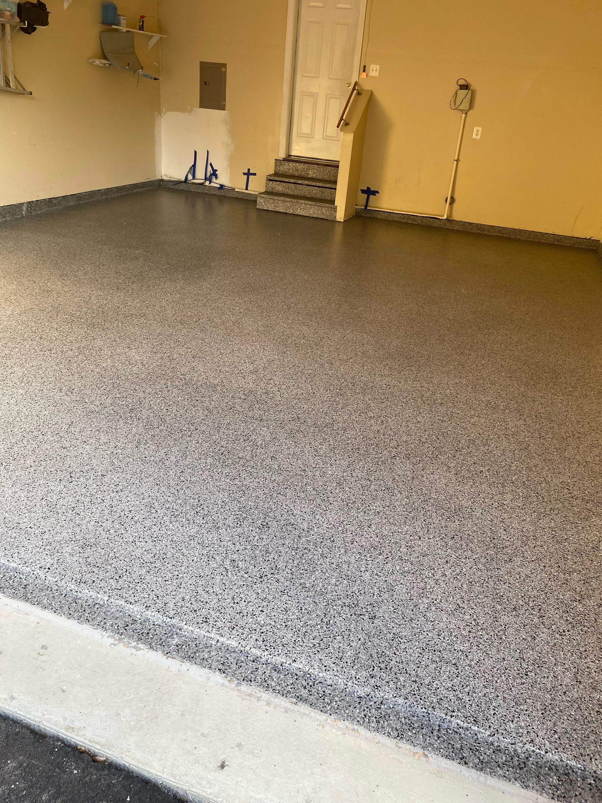 A garage with a gray floor and a door.