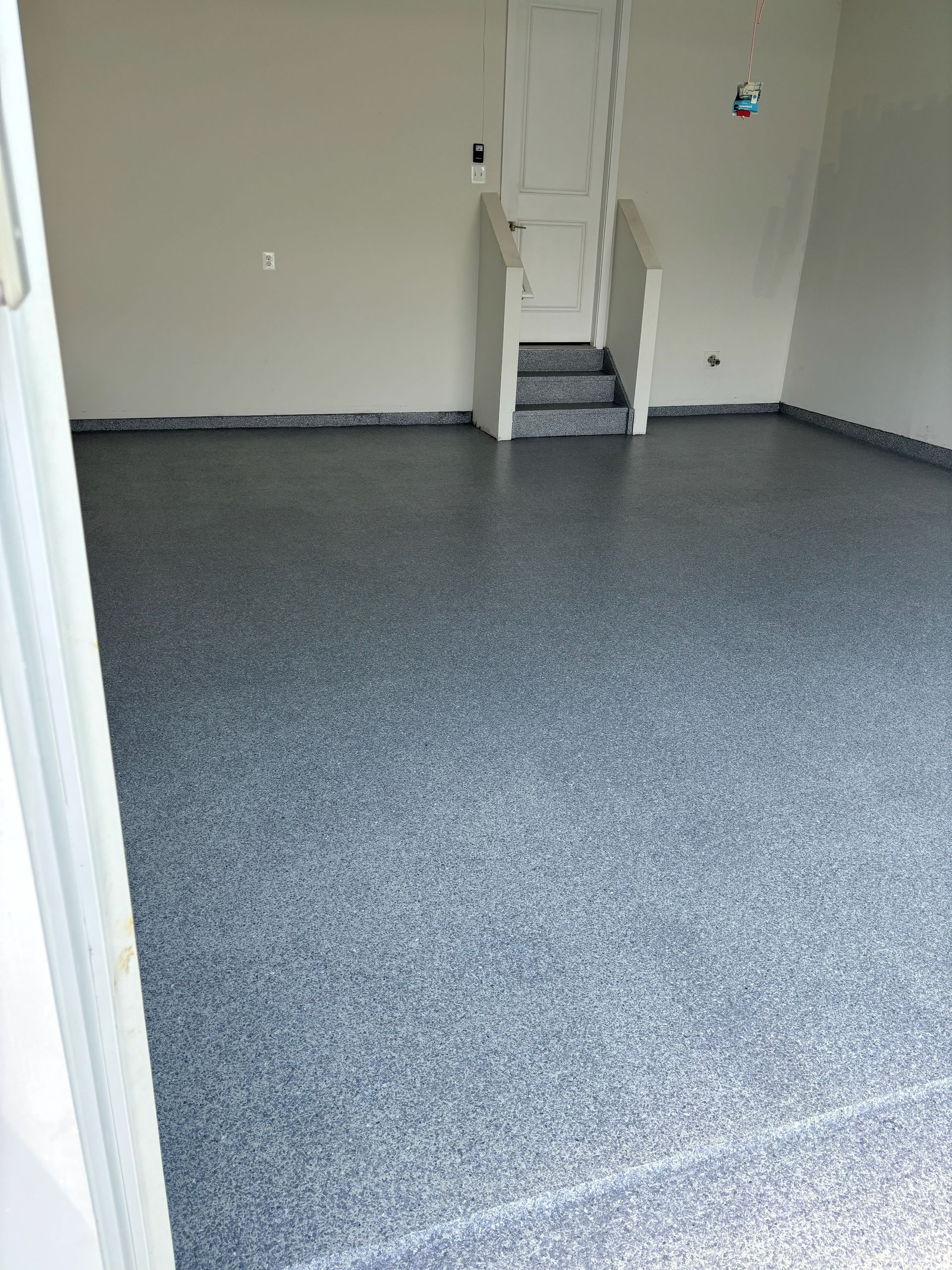 A garage with a staircase leading up to the second floor.
