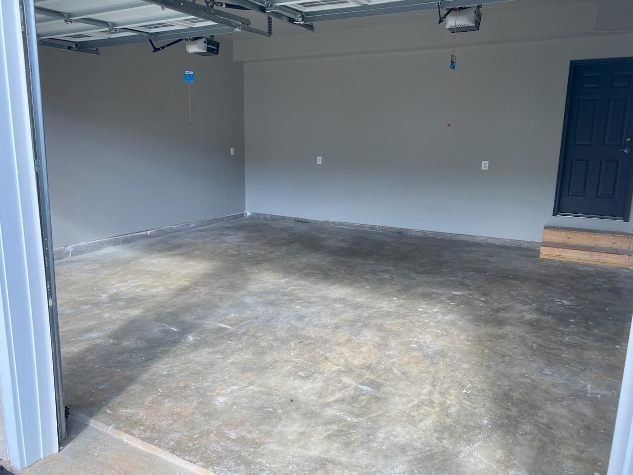 A vacant garage with a coating applied to the floor.
