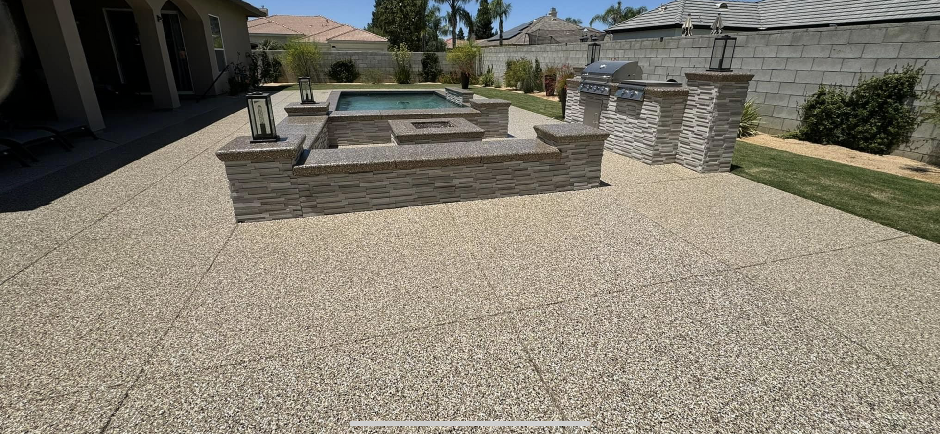 There is a swimming pool in the backyard of a house.