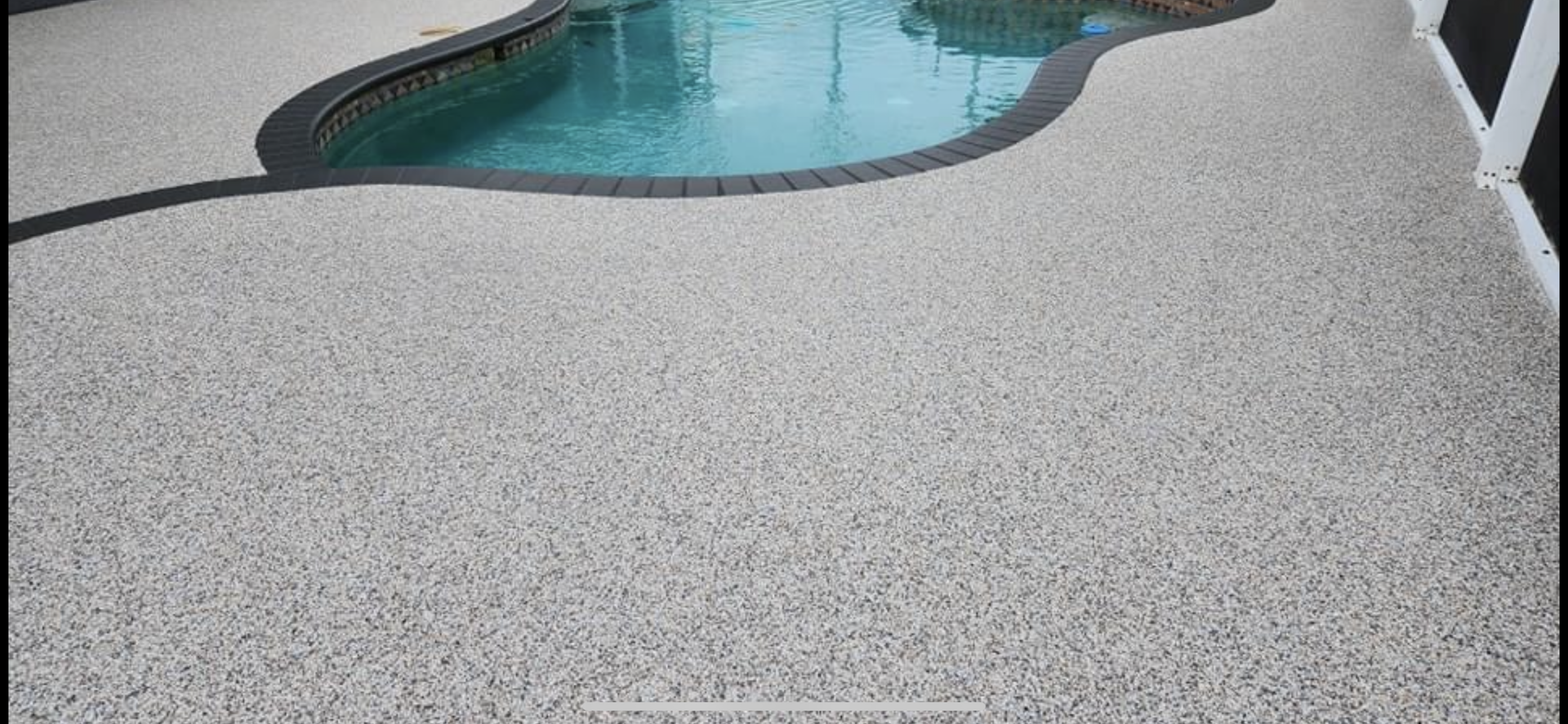 A swimming pool with a concrete floor next to it.