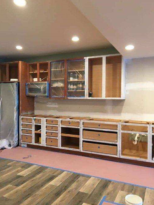 A kitchen under construction with wooden cabinets and drawers.