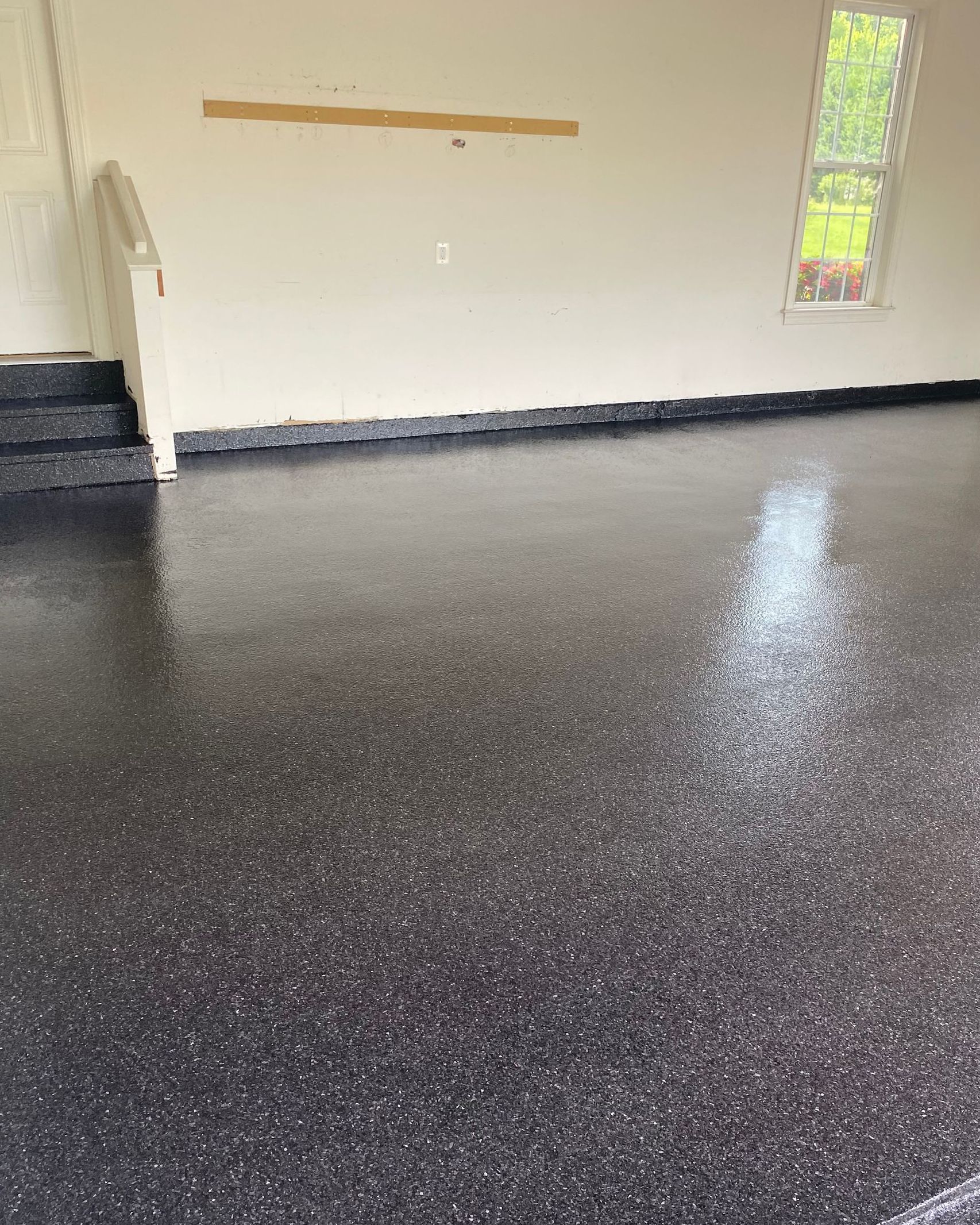 A garage with a black floor and white walls.