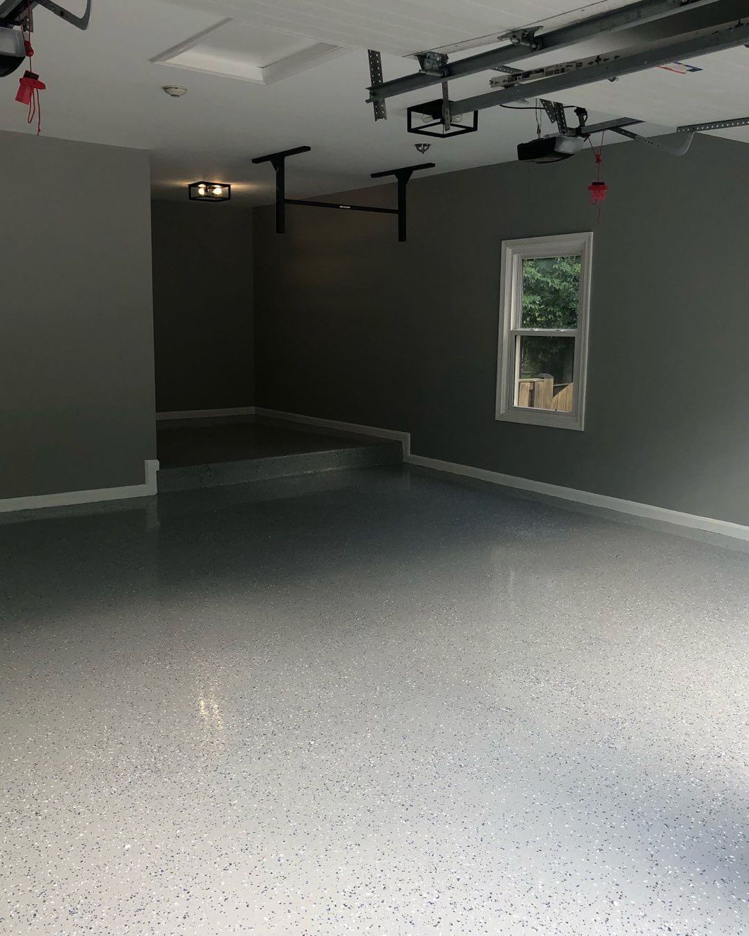 An empty garage with a window and a ceiling fan