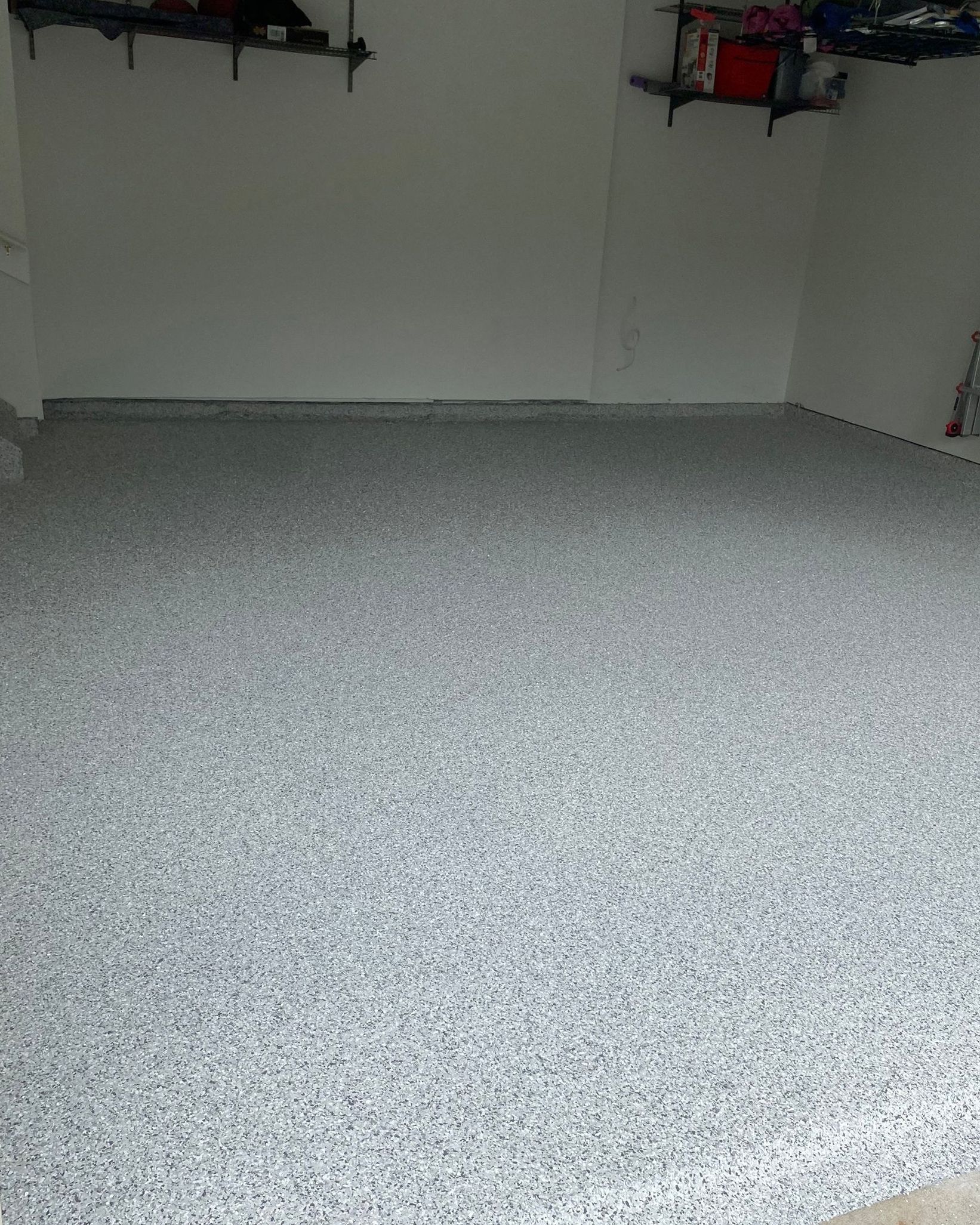 A garage with a gray floor and white walls.