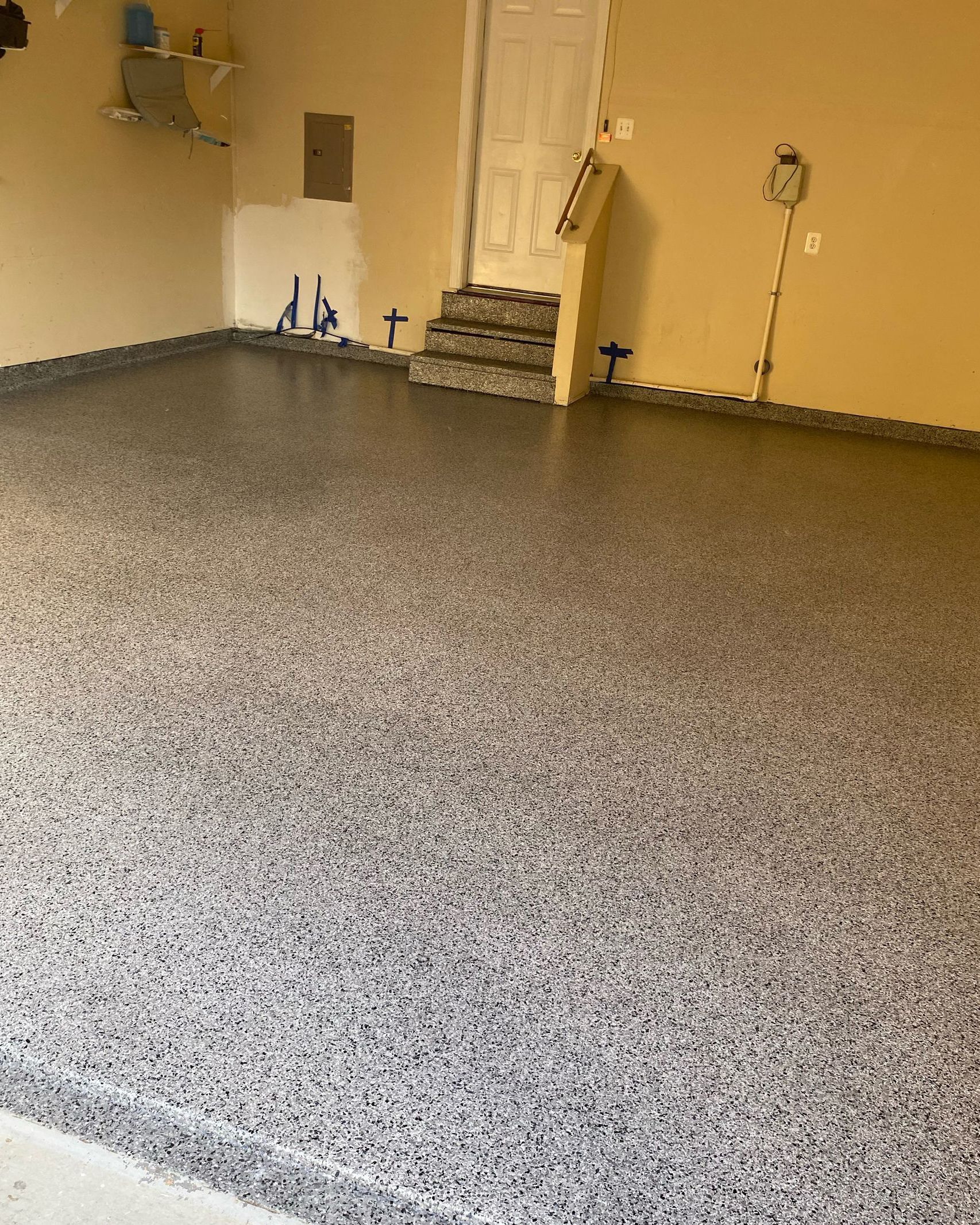 A garage with a concrete floor and stairs.