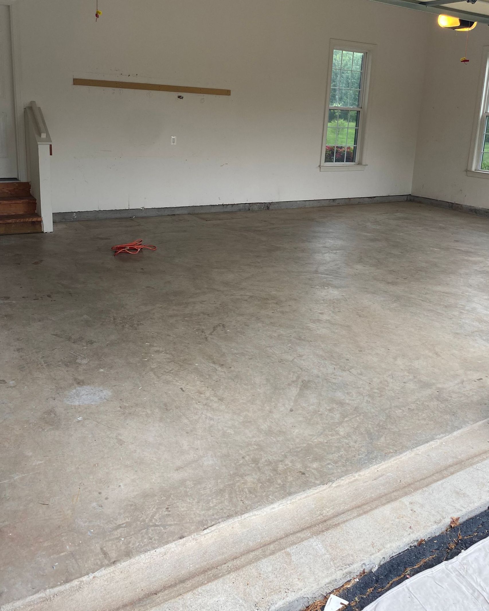 An empty garage with a concrete floor and white walls.