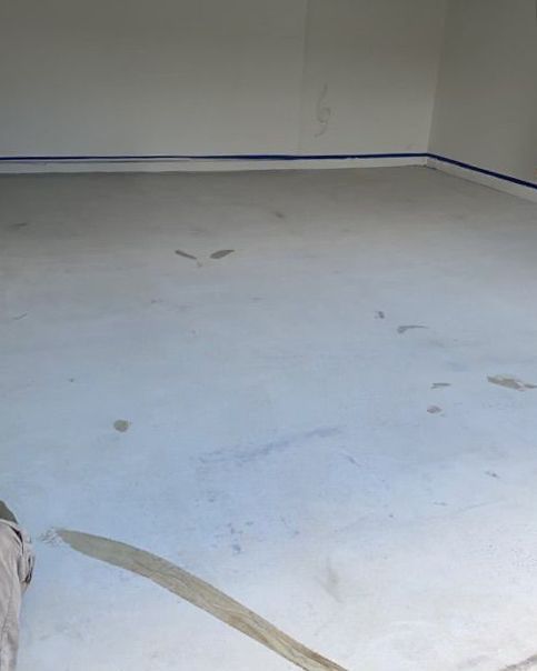 A white concrete floor in a garage with a blue trim.