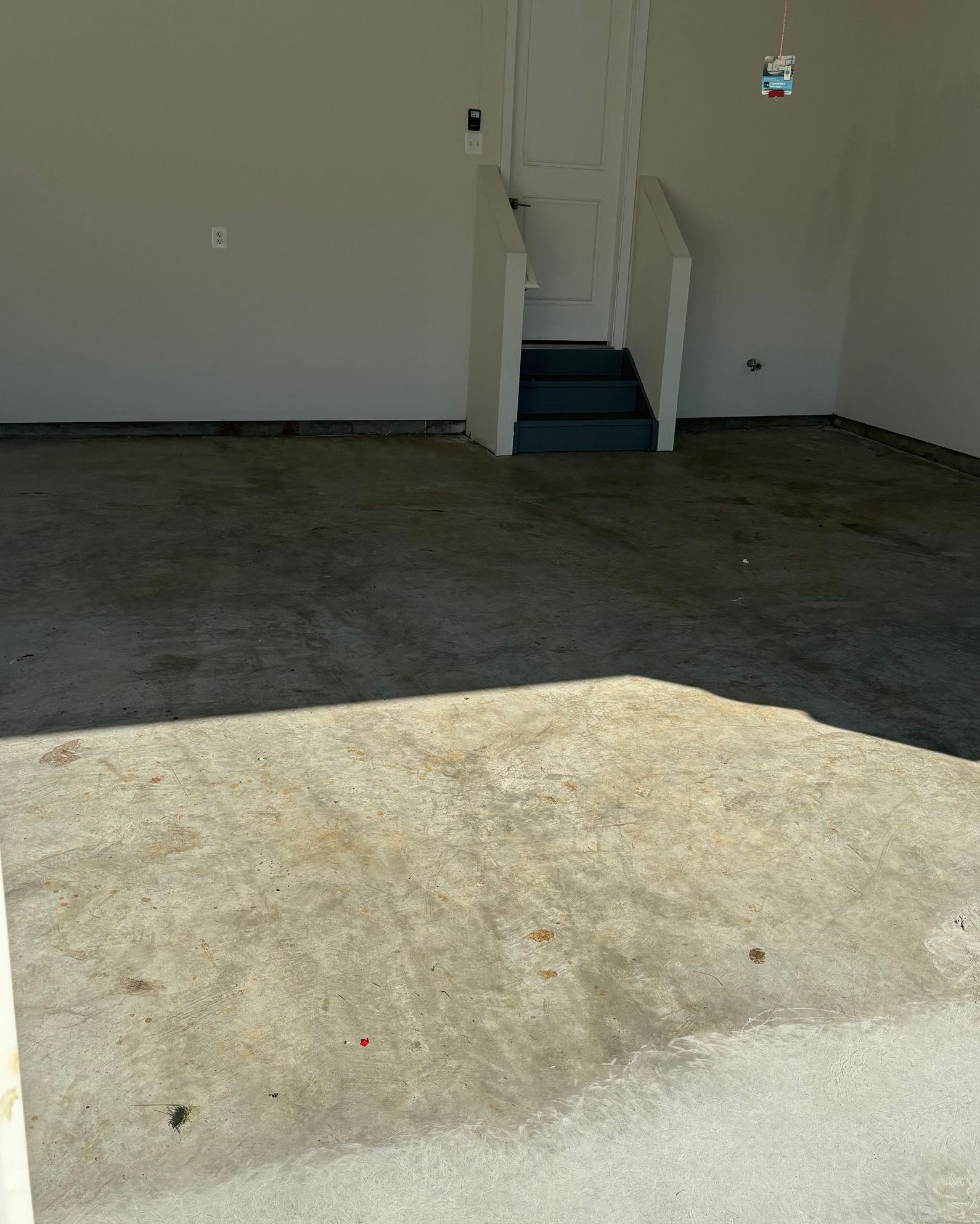 An empty garage with stairs leading up to the door.