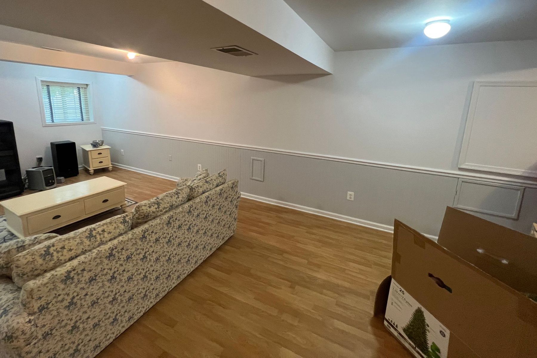 A living room with a couch , table , chairs and a white board.