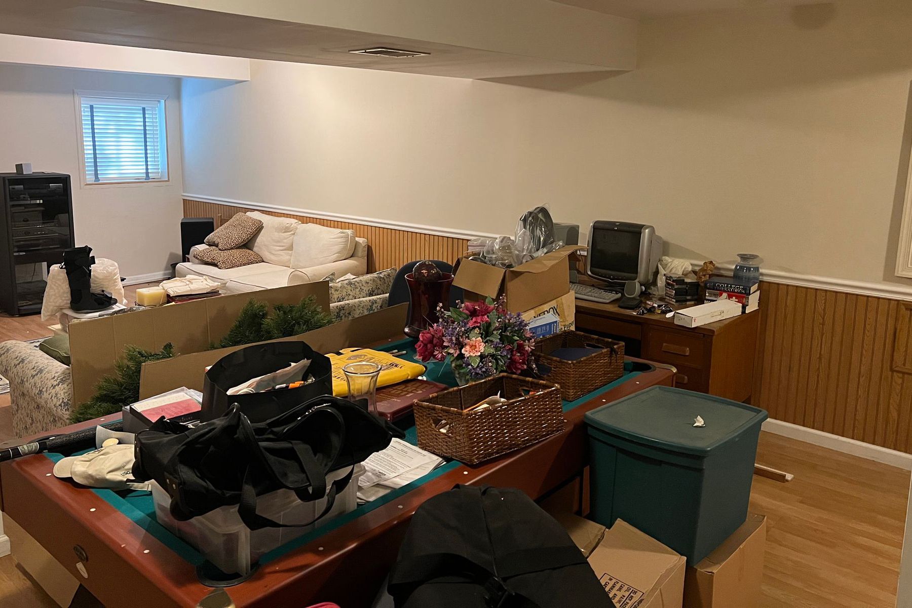 A living room filled with lots of boxes and a pool table.