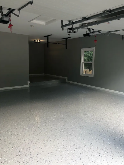 An empty garage with a window and a garage door opener.