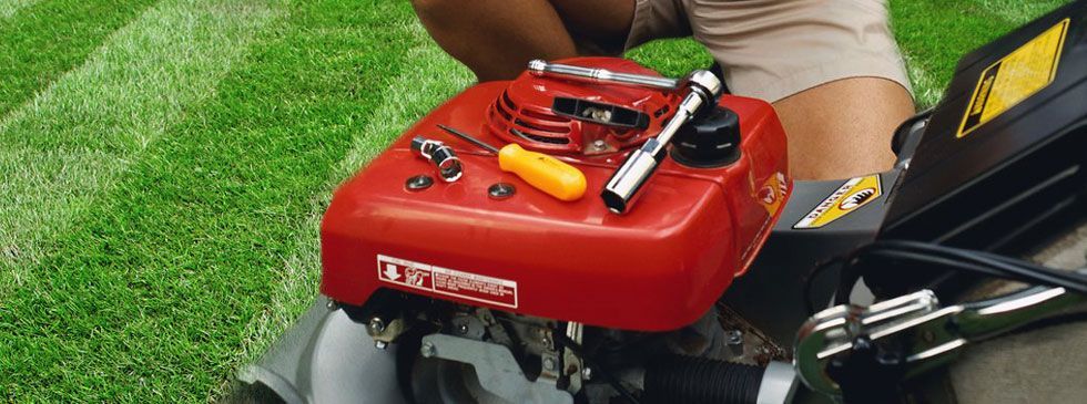 Lawn mower being fixed with tools