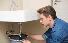 A man fixing a sink.
