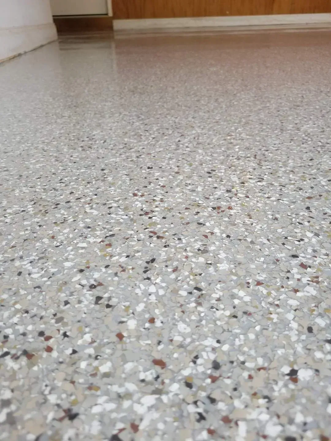 Polished speckled terrazzo floor in an empty indoor hallway