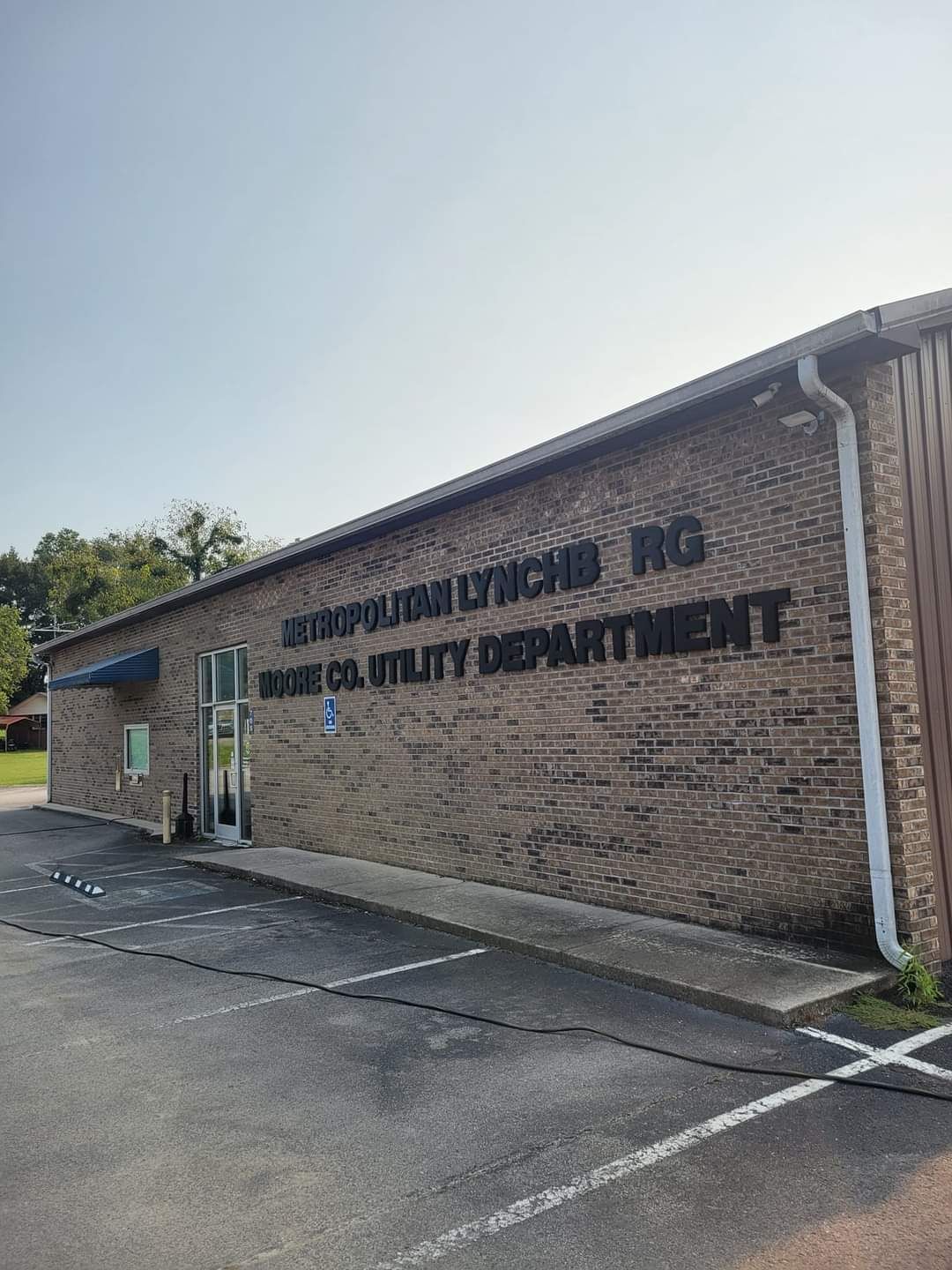 Brick building with a dark sign reading “Family Medical Inc” and “Quality Department” beside an empty parking lot