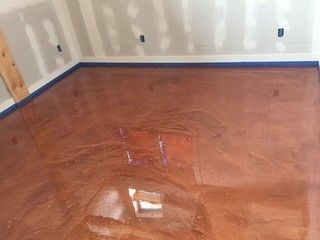 Glossy hardwood floor in an empty room with unfinished walls and blue baseboard trim