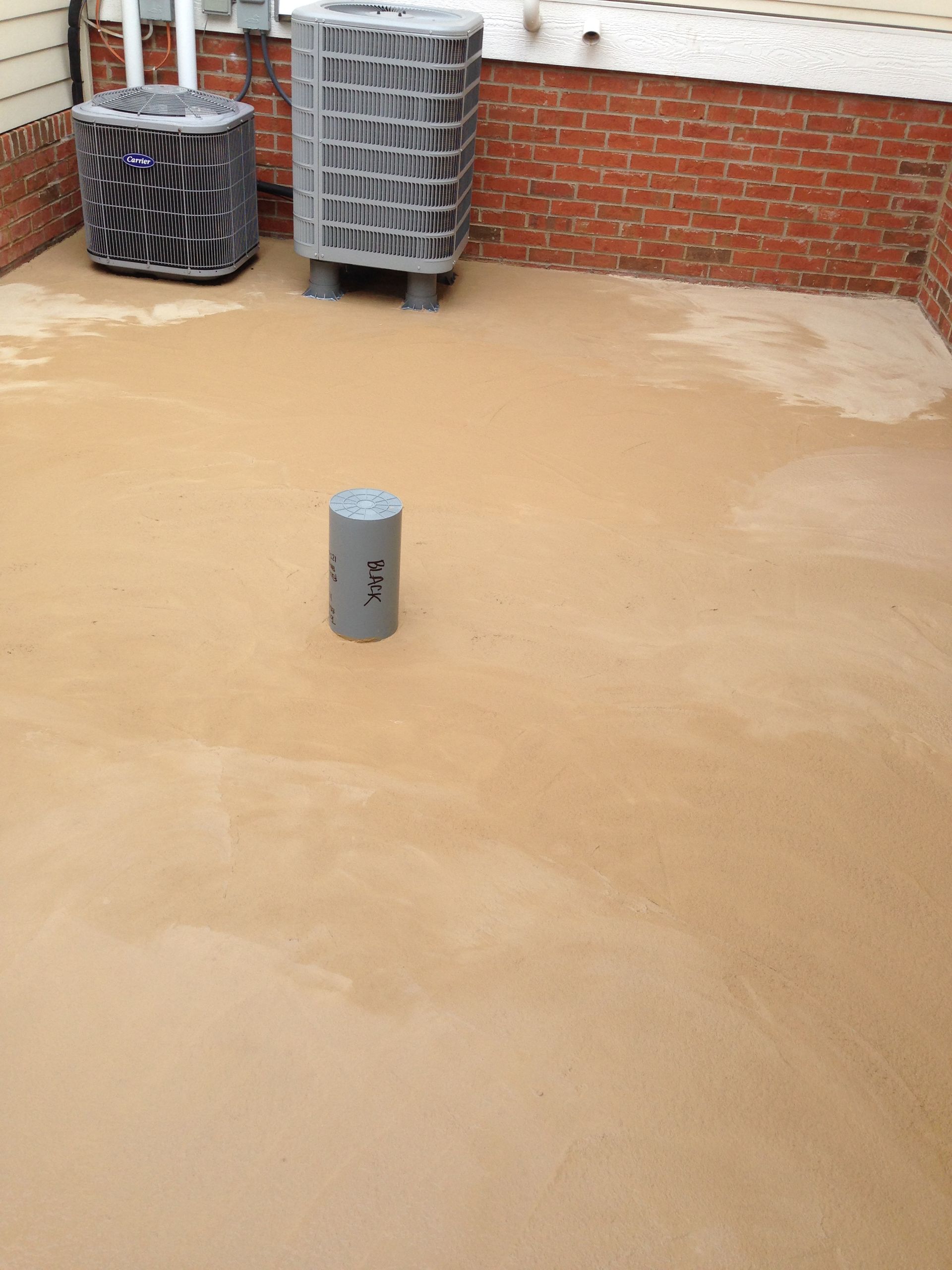 Flooded rooftop with muddy water, trash bins against a brick wall, and a short pipe in the foreground