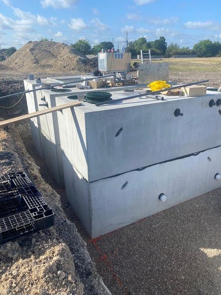 Concrete septic tank installation in a construction site.