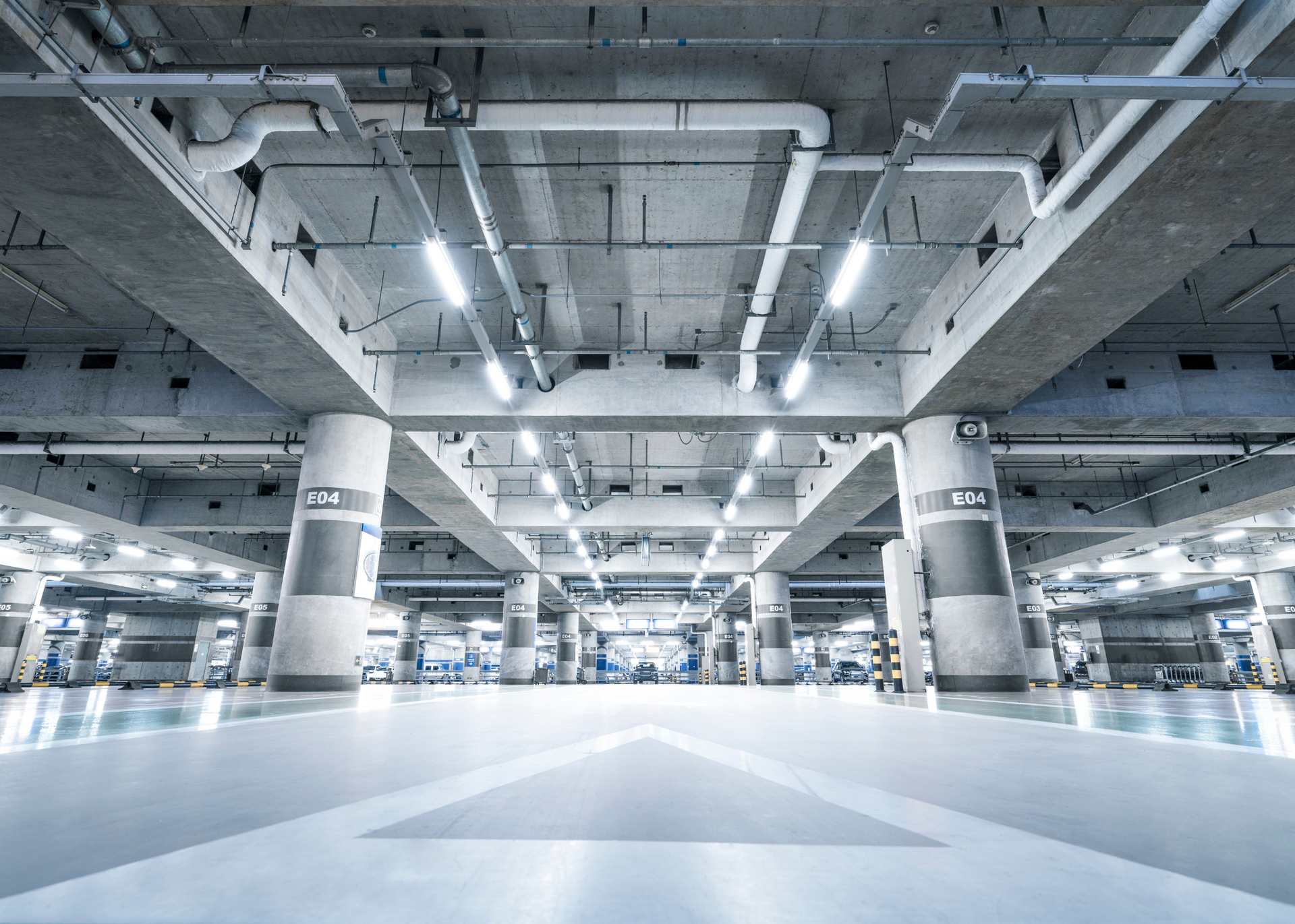 Empty modern industrial warehouse with white concrete pillars and bright overhead lighting