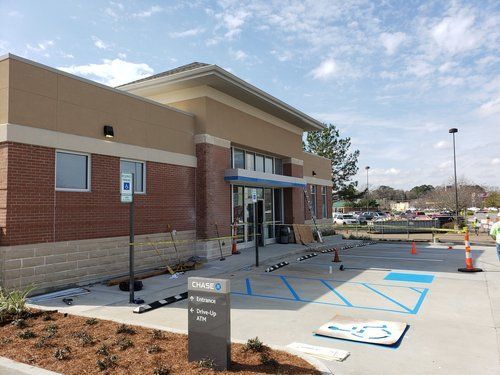 Accessible store entrance with handicap parking spaces and blue curb markings in a lot.