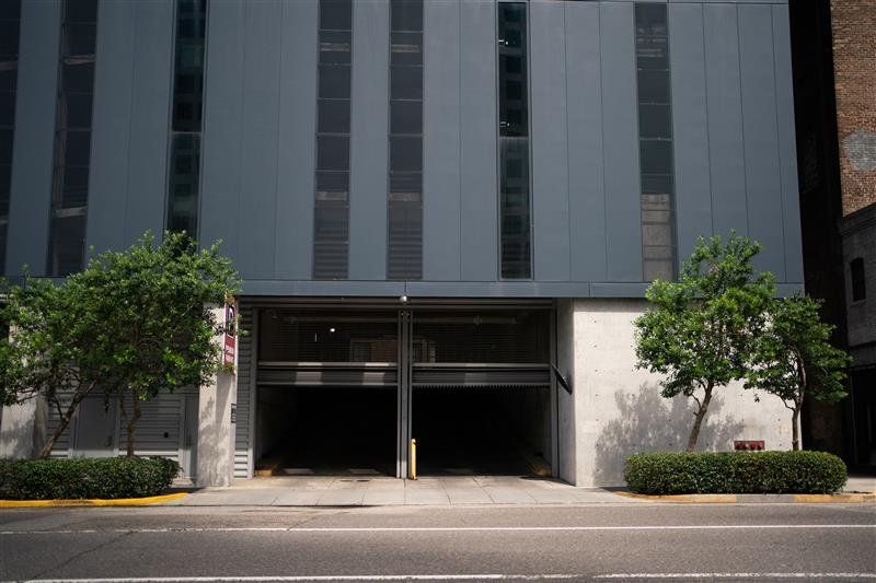 Modern building facade with a recessed entrance and two small trees by the curb