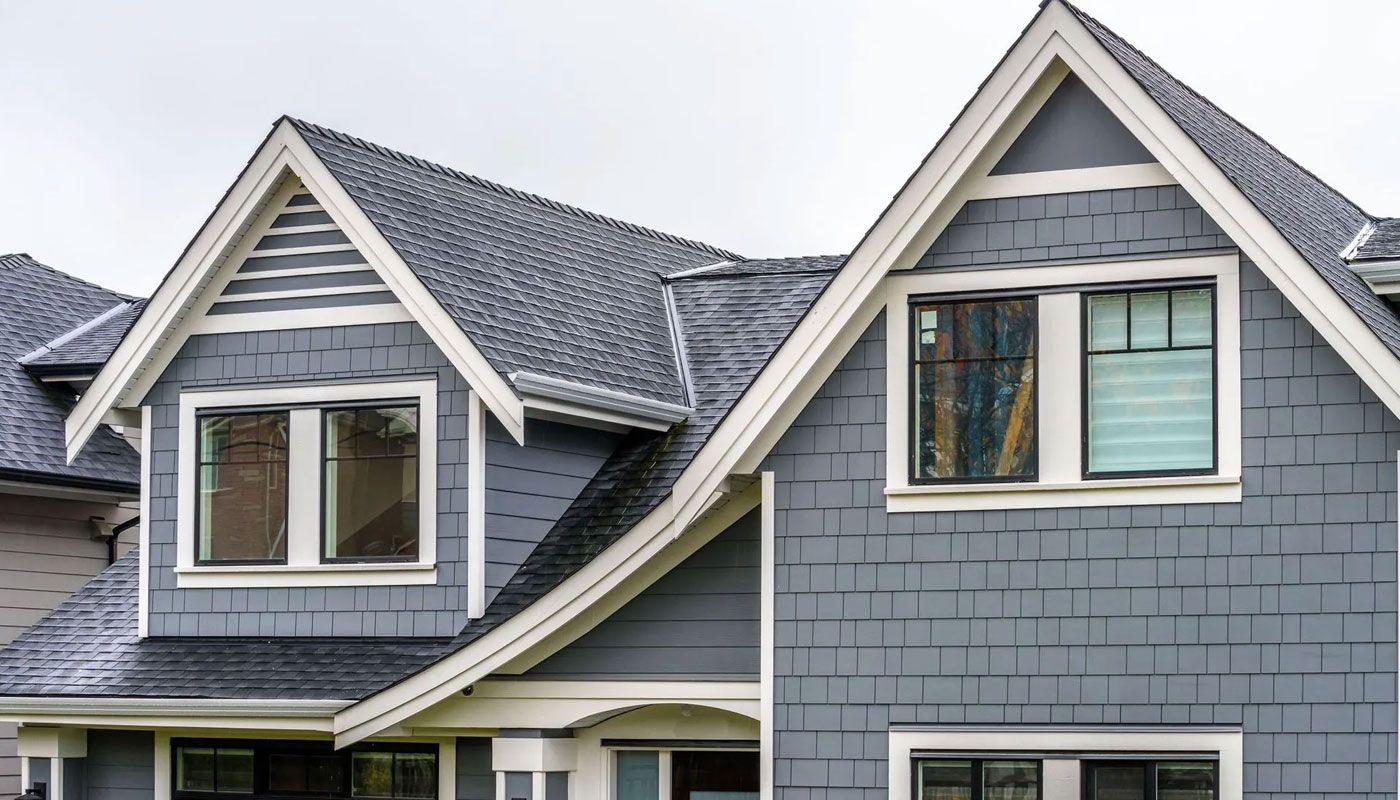 Gray house roof with two dormer windows and white trim