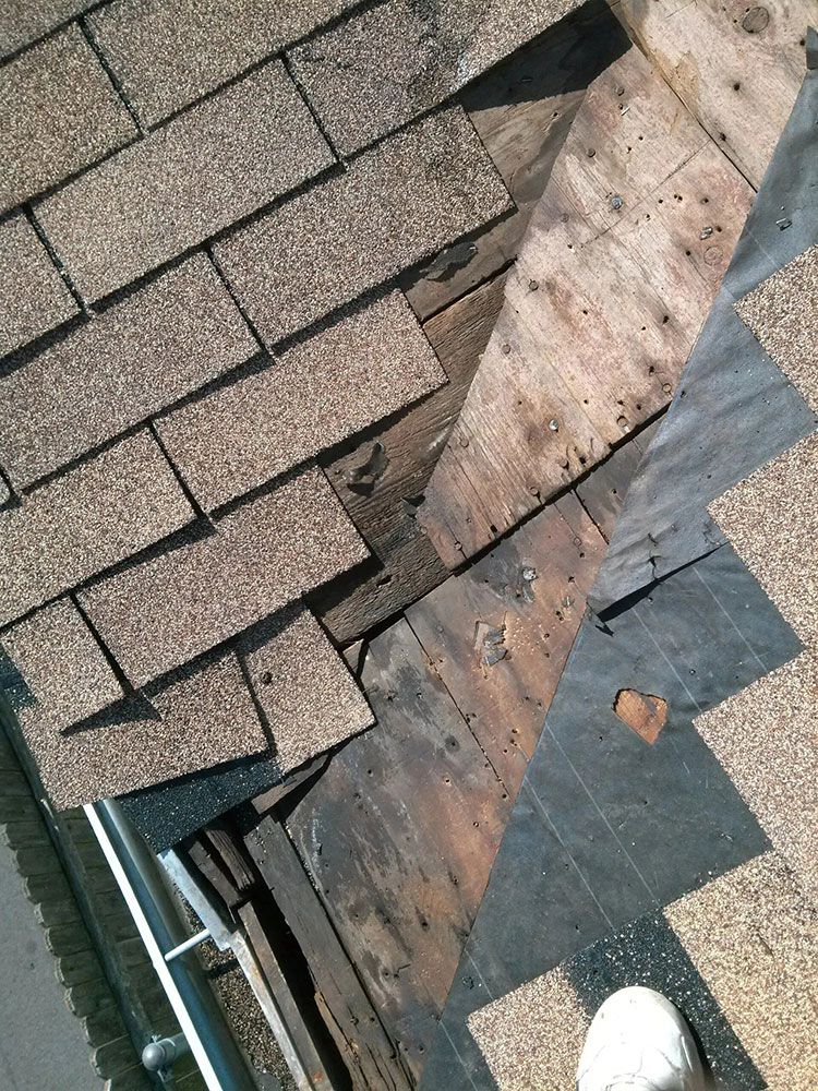 Damaged shingle roof with exposed underlayment and a visible boot on the edge