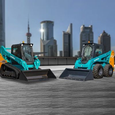 Two turquoise skid steer loaders on a rooftop with a city skyline in the background