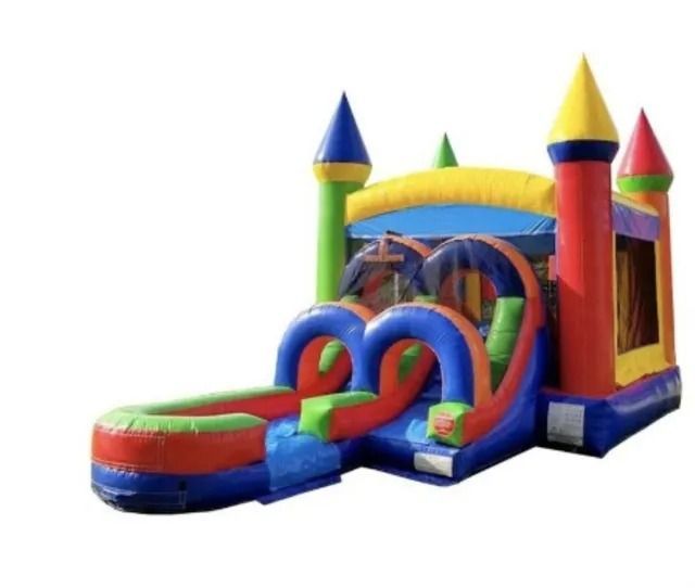 Colorful inflatable bounce house with slide, obstacle arch, and turret towers