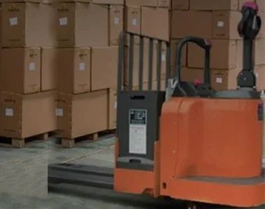 Orange forklift beside stacked cardboard boxes in a warehouse