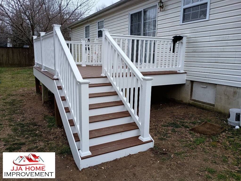 A deck with stairs leading up to it next to a house.