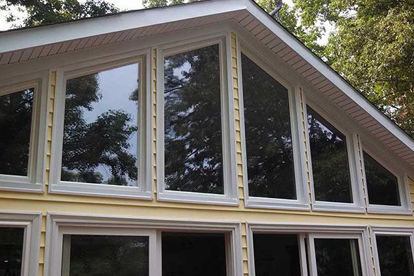 A house with a lot of windows and trees in the background
