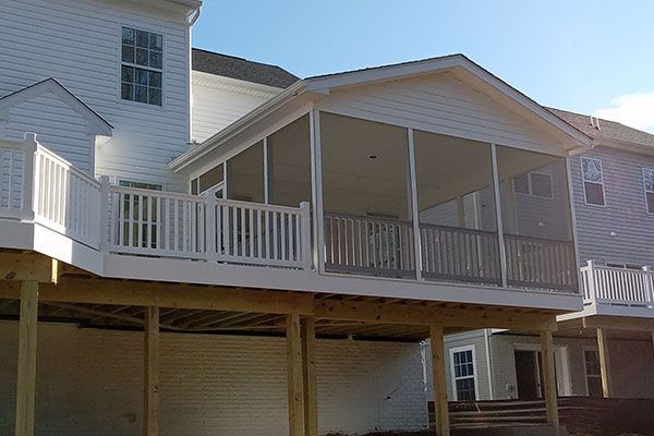 There is a screened in porch on the back of a house.