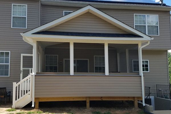 A house with a screened in porch and stairs