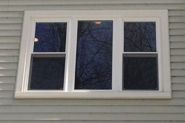 A white window on the side of a house.
