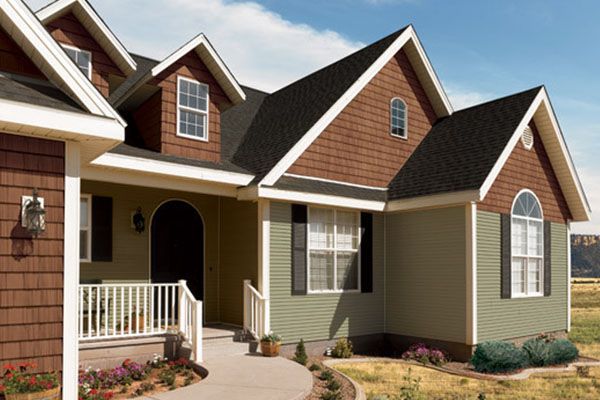 A large house with brown siding and a black roof