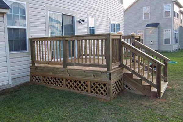 A wooden deck with stairs in front of a house
