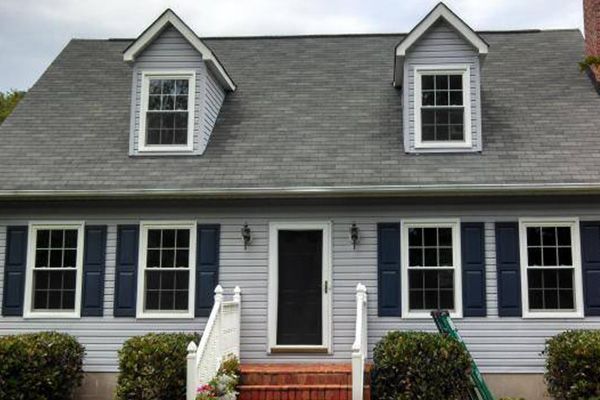 A house with a gray roof and blue shutters
